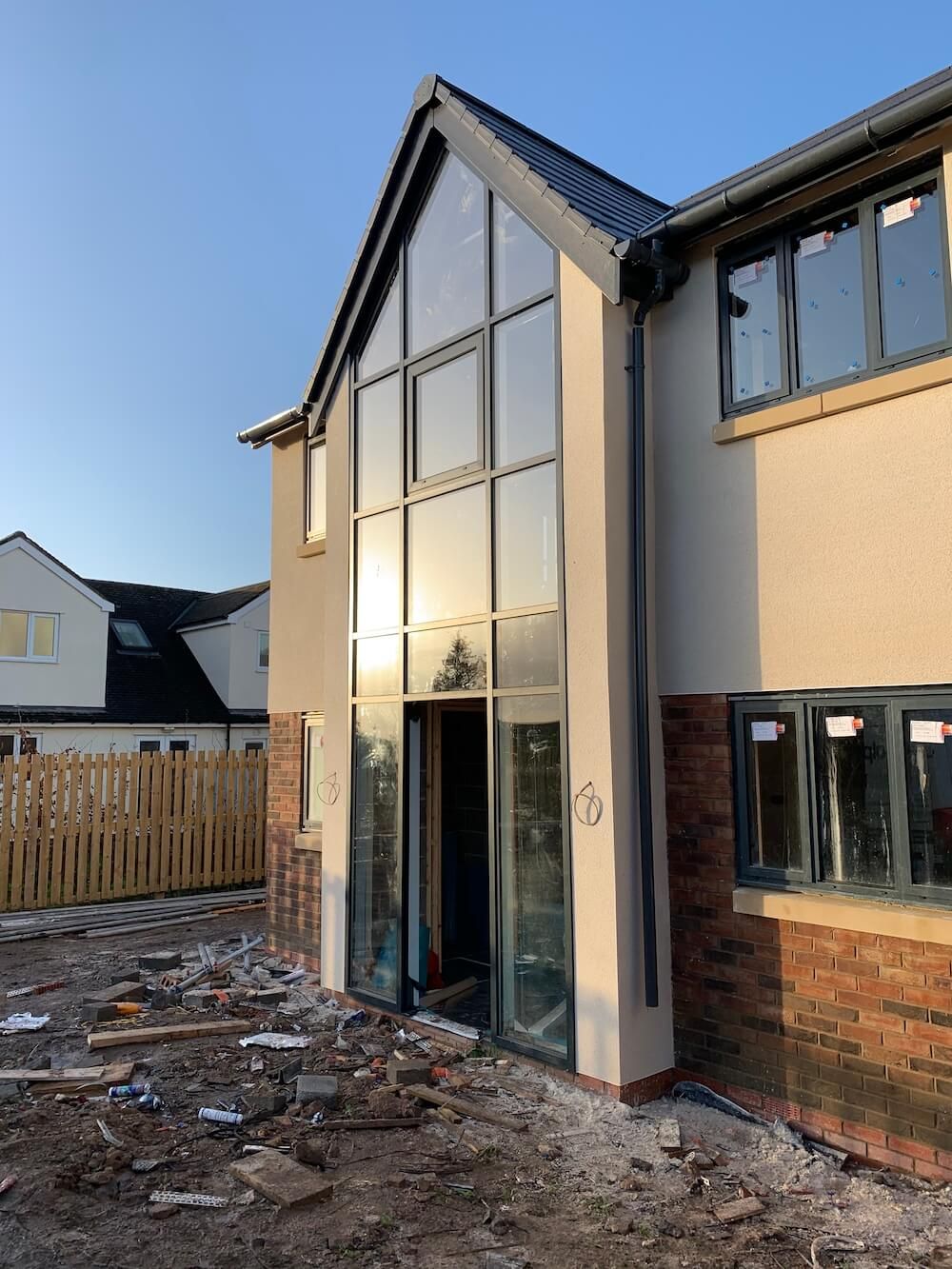 Full-height gable glazing and aluminium sliding doors on a new-build property in Cheshire
