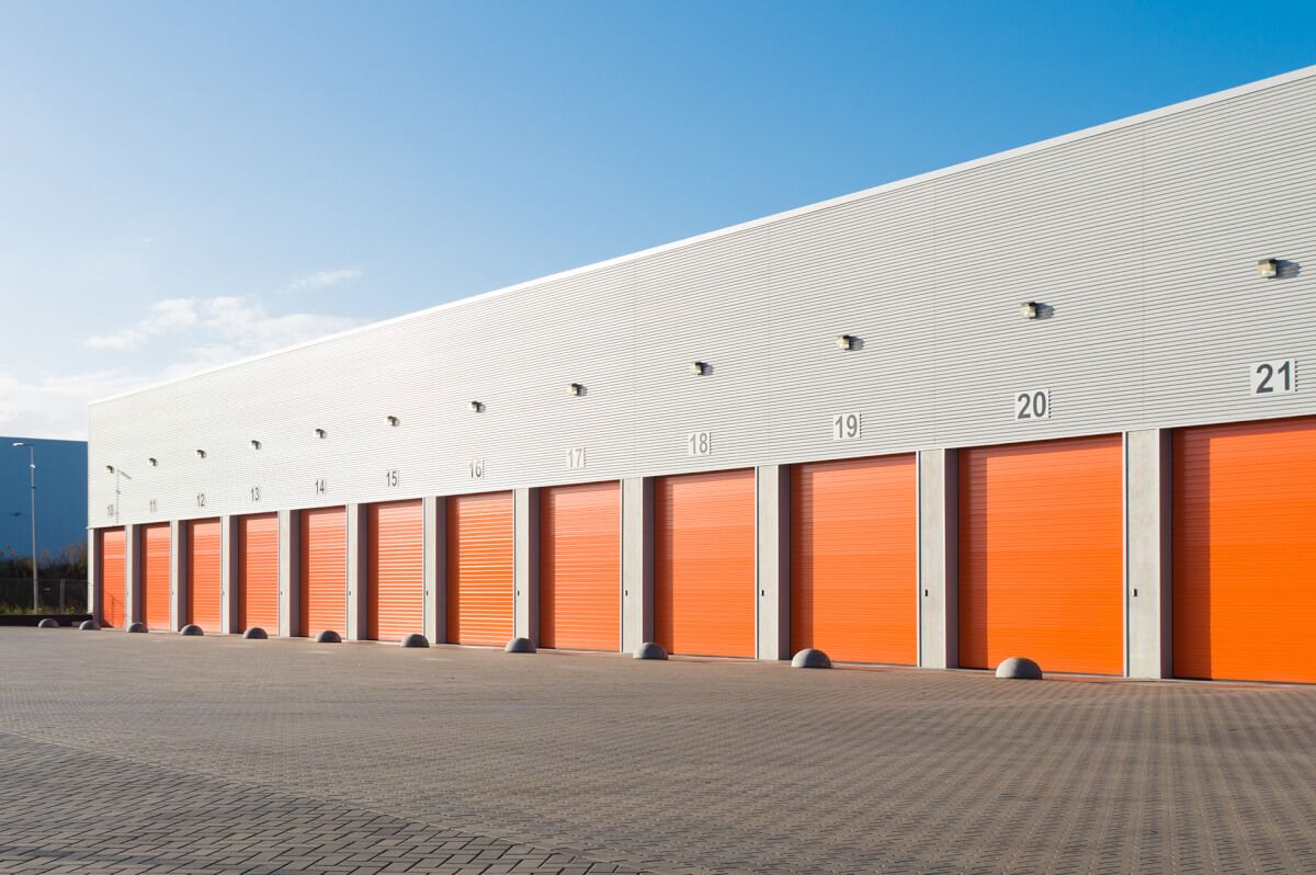 Row of orange industrial roller shutter doors on a commercial unit terrace